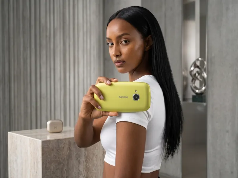 Woman carrying the yellow Nokia 3210 over her shoulder